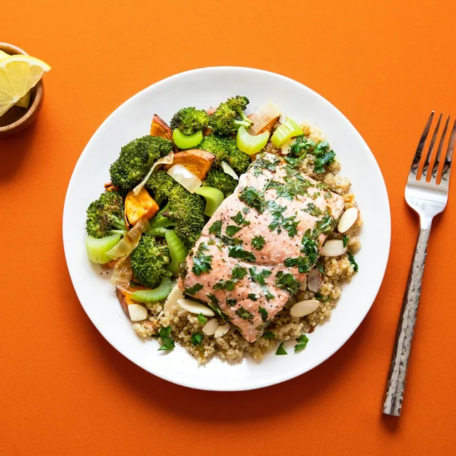 Un plato de salmón al horno sobre quinoa con brócoli y batata, fotografiado para una estimación de Dayli